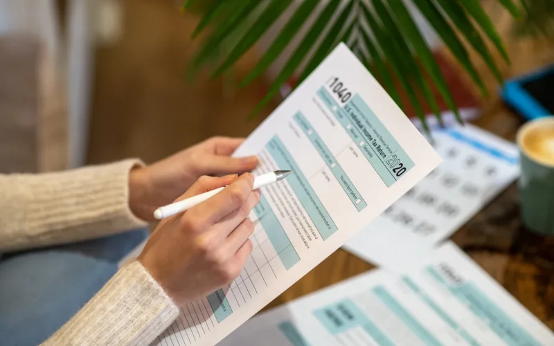 Paying taxes. A woman holding the paper for counting tax expences
